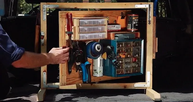 A photo of a portable tool wall hinged so that both sides are accessible. It is resting in the back of a Toyota Landcruiser.